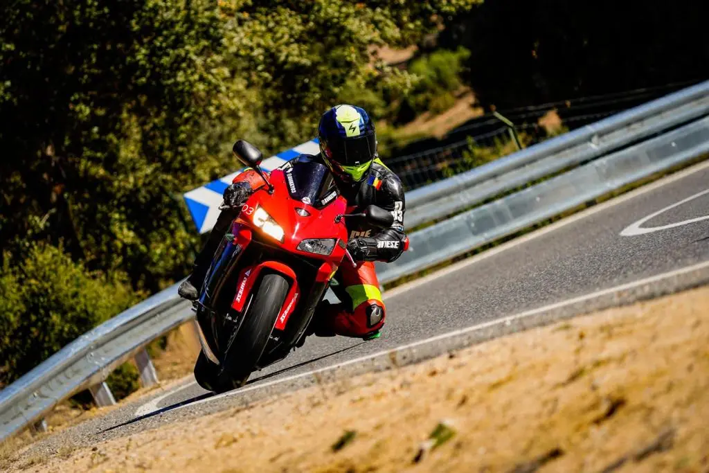 Motociclist intrând într-un viraj cu un combinezon colorat