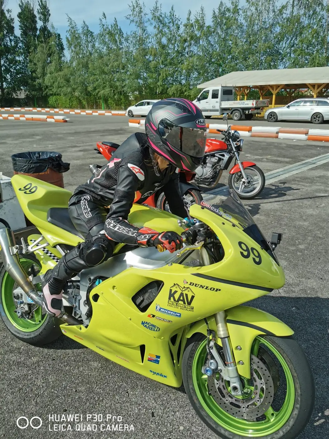 Client lângă o motocicletă galbenă de circuit