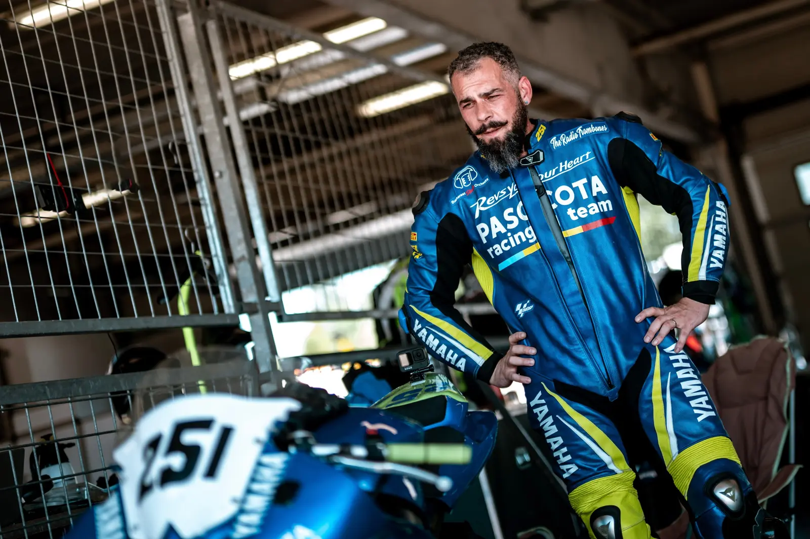Client în combinezon albastru lângă motocicleta de circuit